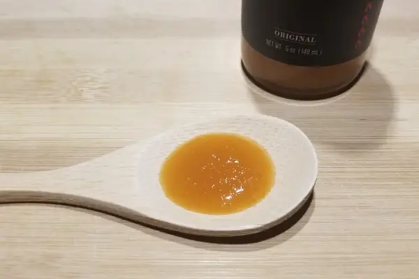 Supernova Original hot sauce on a wooden spoon for taste testing