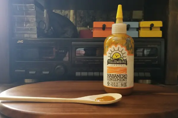 Yellowbird Habanero hot sauce on a board in the sun