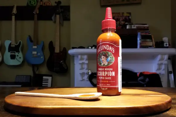 A bottle of Melinda's Scorpion Pepper Sauce and some cool guitars