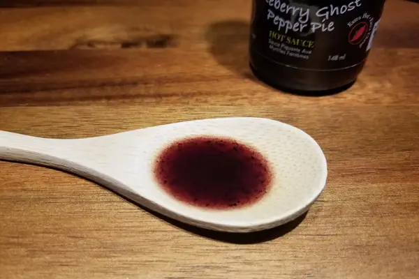 Blueberry ghost pepper pie hot sauce on a spoon