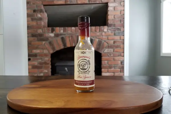 A bottle of Dawson's Cedar Smoked Garlic Hot Sauce