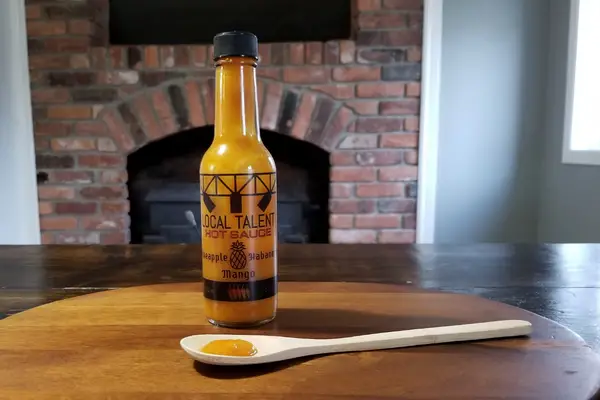 A bottle of Pineapple Mango Habanero hot sauce from Local Talent Hot Sauce