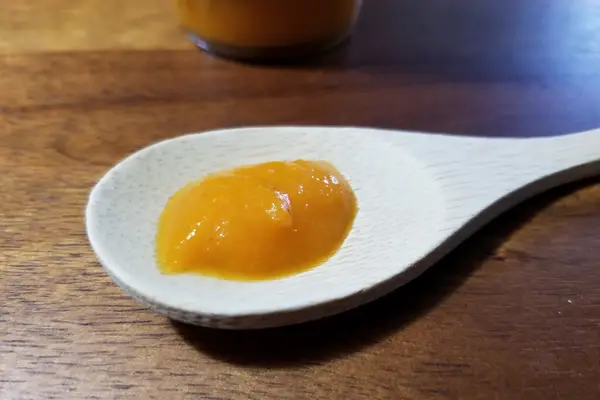 An image of Pineapple Mango Habanero hot sauce on a spoon