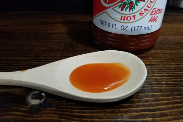 Crystal Extra Hot Sauce on a spoon to show texture.