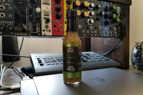 A bottle of Cucumber Habanero hot sauce by Out Of The Box Snacks