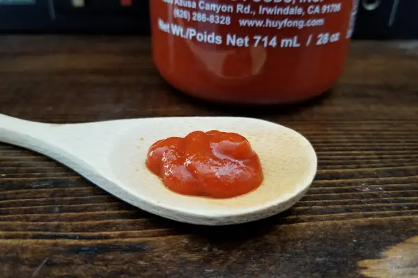 Huy Fongs Rooster Sriracha sauce on a spoon to show texture.