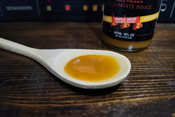 Triple Heat Sweet Potato Hot Sauce by MH Fine Foods on a spoon to show the texture.