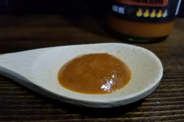 Sweet Carolina Reaper Sauce by Villain Sauce Co on a spoon to show texture.