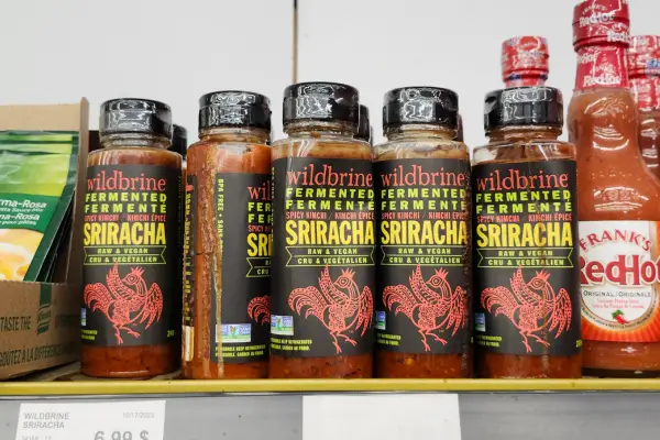 Wildbrine Sriracha sauce exploding on a store shelf